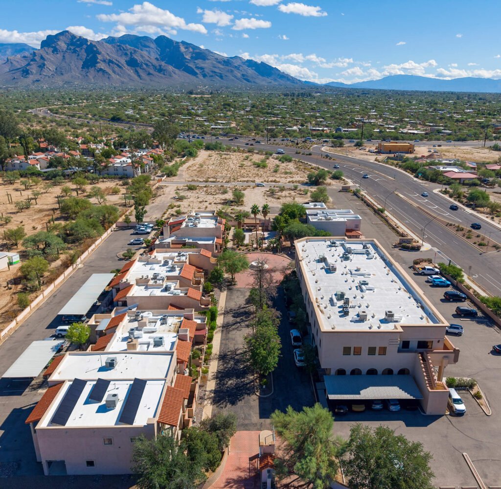 Aerial view of a Tucson commercial building complex showing parking, surrounding roadways, and the Santa Catalina Mountains.